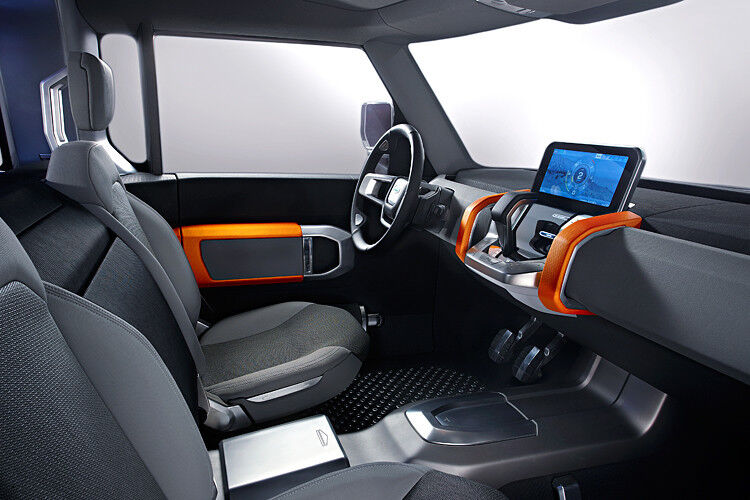 Der Innenraum ist modern, steht Geländefahrten aber nicht im Weg. Der Touchscreen ist laut Hersteller stoß- und wasserfest. Mit eigener Stromversorgung, Festplatte, Satellitenempfänger und Kamera soll er auch außerhalb des Fahrzeugs nützlich sein. (Foto: Jaguar Land Rover)