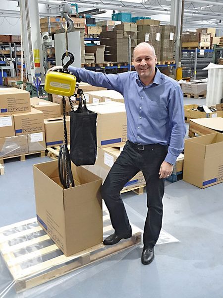 Mit Stolz präsentiert der Geschäftsführer der GIS AG, Ivan Muri, den ersten Elektrokettenzug der neuen Generation GP, welcher in der Speditionsabteilung zum Versand bereit gemacht wird. (GIS AG)