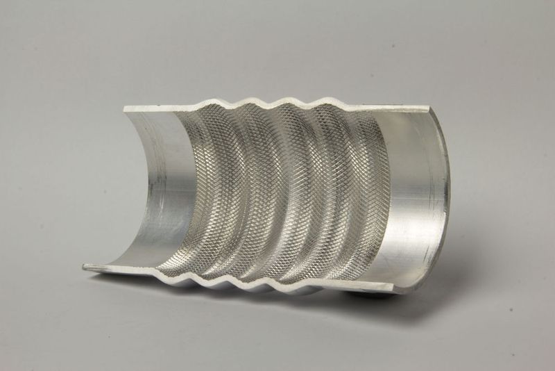 Mittels intrinsischem Schlauchblas-Integral-Verfahren, können die Tape-Preforms aus CFK und dieser innenkonturierte Metalleinleger (Hier ein Schnitt durch das Element) automatisiert gefertigt und miteinander verbunden werden, wie es heißt. (Bild: TU Dresden)