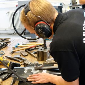 Julian Barth (Karosserieinstandhaltungstechnik) bringt die ehemals stark deformierte Stelle des Frontblechs wieder in Form.(Bild:  Dominsky – VCG)