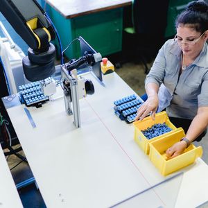 Der Mensch steuert und kontrolliert die Arbeitsprozesse und der Roboter führt sie aus.