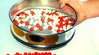 Stellen Sie sich ein Sieb vor, das Kugeln gleicher Größe, aber unterschiedlicher Farbe trennt – was in unserer sichtbaren Welt nicht möglich ist, funktioniert auf Quantenebene. (Bild: Universität Augsburg/Prof. Dr. Dirk Volkmer)