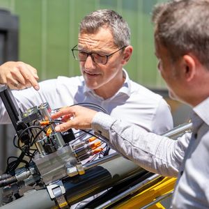 Bernd Winkler und RWT-Vorstand Reinhard Thor besprechen das Wechselspiel der vier Schieber-Sitzventile am CPS-Block beim Eilgang und Regenerationsgang.(Bild:  Pecksteiner/LCM)