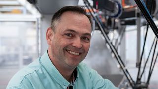 Der Autor Andreas Schildknecht, Produktmanager Robotik bei Syntegon. Im Hintergrund ein Deltaroboter.
 (Bild: BOSCH PACB-MKT)