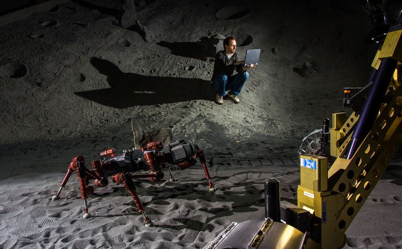 DFKI-Forscher testen das RIMRES-System in der hauseigenen Weltraum-Explorationshalle. Projektmitarbeiter Thomas Röhr überwacht die Übungsmission in der künstlichen Kraterlandschaft. (Bild: DFKI/Florian Cordes)