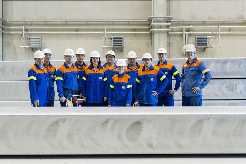 Team-Mitglieder von Novelis stehen neben neu gegossenen Aluminiumbarren im neuen Recyclingwerk in Nachterstedt. (Bild: Novelis)