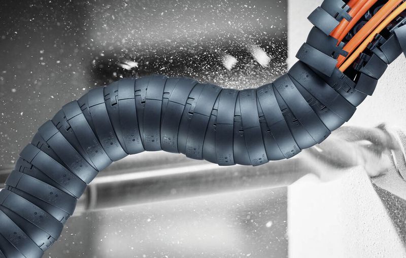 Wenn große Mengen von abrasivem Staub anfallen, dann bewährt sich die dreidimensional bewegliche, geschlossene Triflex R-Kette von Igus in Kombination mit einem Rückzugssystem.  (Bild: Igus)