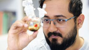 Ankur, Doktorand von Professor David Scheschkewitz, betrachtet die Probe mit Pentasilacyclopentadienid. (Bild: Thorsten Mohr/UdS)