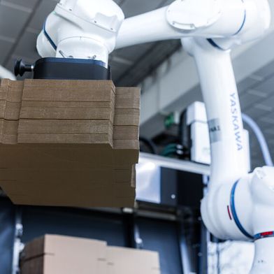Der Somic „CoboLoad“ sorgt für eine automatische Kartonversorgung der Maschine – ohne dass dabei ein Mensch eingreifen muss. Herzstück der Lösung ist ein Cobot HC20DTP von Yaskawa. (Bild: Yaskawa)