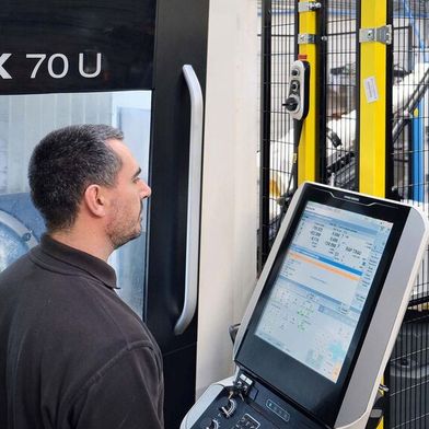 Mr Slimm at the control of the automated DMG Mori CMX 70 U VMC. The robot enclosure with safety fence and light curtain may be seen in the background. (Source: Whitehouse Machine Tools )