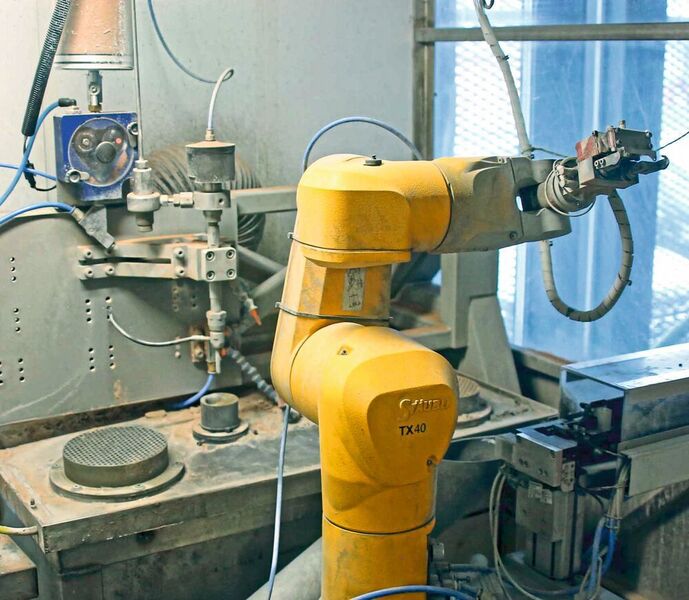Der Roboter greift die orientiert zugeführten Bauteile und erzeugt 3D-Schnitte, indem er sie durch den Strahl des fest montierten Schneidkopfs führt. (Vollrath)