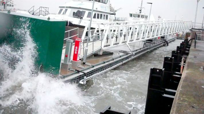 Bild 16: An diesem Ponton im britischen Barrow-in-Furness werden die Service-Boote eines Windparkbetreibers fit für den Einsatz gemacht. Hierfür werden Dieselleitungen sowie Schläuche und Kabel für Lenzpumpen von Land auf die Pontons geführt. Damit diese in der rauen Umgebung zuverlässig vor Beschädigungen geschützt sind, wurde eine 20 m lange e-kette der Serie 1640 von igus verwendet. Die führt auch die 100 mm starken Kraftstoffleitungen sicher ans Ziel und ist völlig unempfindlich gegen salzige Luft und raue See. (Bild: Cameron Forecourt)