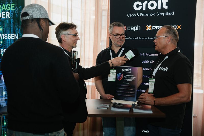 Storage-Insider mit Redakteur/Kameramann Marvin Djondo-Pacham (l.) und Chefredakteur Dr. Jürgen Ehneß sprach mit dem „Standpersonal“ der DSX-Partner für Linkedin-Kurzfilmchen – hier am Croit-Stand. (Bild:  Manuel Emme Fotografie)