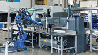 Ein Roboter Motoman GP50 von Yaskawa übernimmt an der Schneidemaschine das Handling des Papierstapels und kann dabei das Fingerspitzengefühl eines menschlichen Bedieners simulieren.
 (Bild: Yaskawa Europe GmbH)