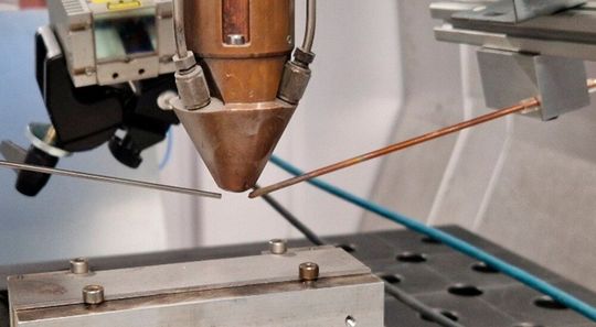 Reales Bild der Neuentwicklung vom Fraunhofer IPK zum echtzeitfähigen T-Stoß-Schweißen im Leichtbau. Gut sind die beiden Kupferelektroden zu sehen, die später in der Metalldampfwolke die Informationen aufnehmen.(Bild:  Fraunhofer IPK)