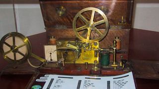 Samuel Morse entwickelte im 19. Jahrhundert einen Apparat, der aus einem Stift, einem Pendel, einem Uhrwerk, einer Papierrolle und einem Elektromagnet bestand. Dieses Instrument konnte zum ersten Mal Nachrichten mithilfe von Elektrizität übermitteln. (Bild: Morse Telegraph 1837 / Zubro / CC BY-SA 3.0)