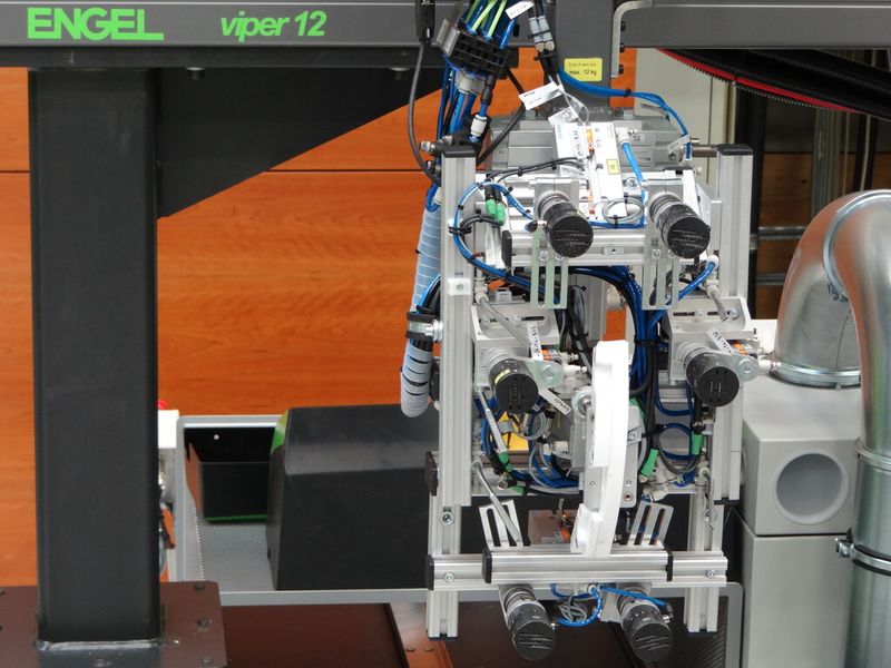 Handlingsystem zum positionsgenauen Ablegen und Fixieren der Zuschnitte im Preformwerkzeug. (Bild: Engel)