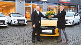 Markus Krohn, Präsident des Kfz-Landesverbandes Hamburg, überreichte Toni Endres den Gewinn des diesjährigen Licht-Tests. Nebst einem nagelneuen Mitsubishi gab es noch einen Blumenstrauß.  (Bild: Peter Vogel, Hamburg)