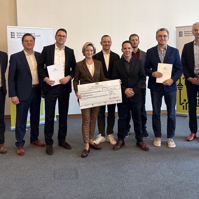 Wirtschaftsministerin Nicole Hoffmeister-Kraut (Mitte) übergab am 4. März 2026 den Förderbescheid für das Industrial Metaverse Reallabor. Vor Ort dabei waren außerdem (von links): Benjamin Schneider, Oliver Schöllhammer, Moritz Hämmerle, Andreas Bareiss, Alexander Kreische, Volker Helzle, Peter Froeschle, Georg Schnauffer und Heike Wohlfeld.
 (Bild:  Ministerium für Wirtschaft, Arbeit und Tourismus Baden-Württemberg)