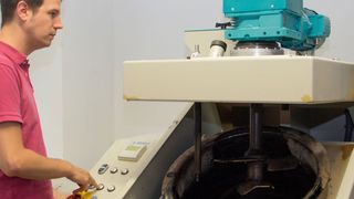 Bernhard Hofko mit der Prüfmaschine, mit der die Verabeitbarkeit von Asphaltmsichgut bei der Produktion bestimmt wird. (Bild: TU Wien)