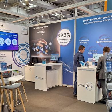 Revolution im Shopfloor: Auf der Hannover Messe 2026 präsentiert Industrie Informatik das KI-gestützte Cronetwork MES als zentrale Plattform für die Smart Factory – mit Advanced Analytics, transparenter Fertigungssteuerung und nahtloser Integration zwischen Shopfloor und ERP (Halle 14, Stand H14). [Anmerkung der Redaktion: Das Bild zeigt den Messestand auf der Hannover Messe 2025.] (Bild: Industrie Informatik GmbH)