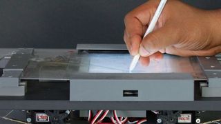 Das Foto zeigt ein Modell, bei dem deutlich zu sehen ist, wie der Multilayer unter dem Druck des Stiftes nachgibt. Der Motor steuert die Spannung des Multilayers. (Ernst Kruijff/H-BRS)