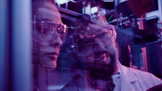 Dr. Christoph Wulf (rechts) mit Dr. Denise Heyl an einer Fischer-Tropsch-Anlage im Labormaßstab. In dieser Anlage werden katalytische Verfahren zur Gewinnung flüssiger Kohlenwasserstoffe aus Kohlendioxid und Kohlenmonoxid erprobt.(Bild:  Likat)