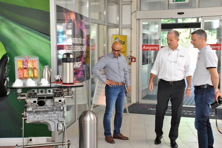 Ja, da schaut der geneigte Kfz-Spezialist: Filialleiter Andreas Strauß (Mitte) erklärt, wie es ein V8-Motor schaffte, zur Kaffeebar zu mutieren. (Dominsky)
