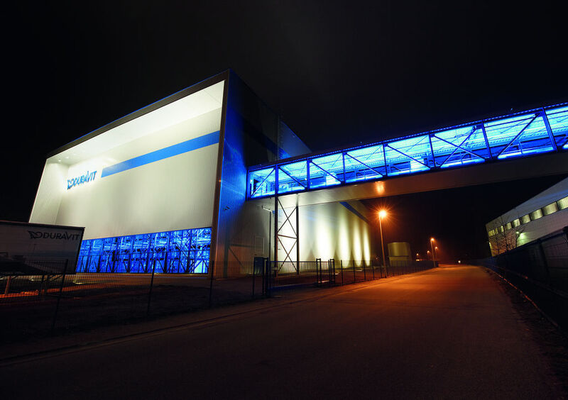 Duravit baut weltweit ein einheitliches Unternehmens- und Markenbild auf, zu dem auch das neue Gebäude mit seinem Erscheinungsbild passt: Nachts erstrahlen die Verbindungsbrücke und eine Fensterfront des Lagers in magischem Blau. (Archiv: Vogel Business Media)