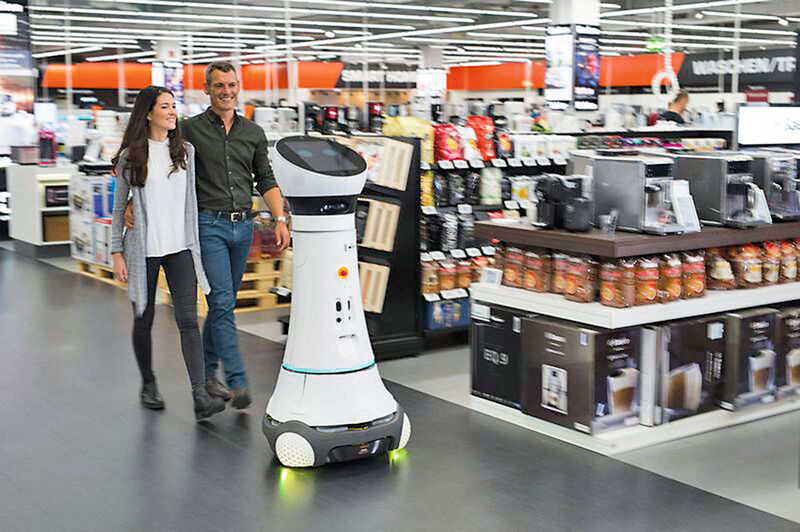 Ein freundliches Miteinander: Als Roboter Paul begrüßt Care-O-bot 4 seit Oktober die Kunden bei Saturn in Ingolstadt und begleitet sie zum gewünschten Produkt. (Fraunhofer-IPA)