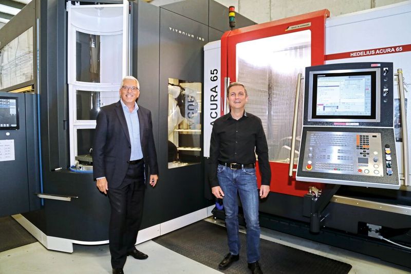 Bruno Tscharner (rechts), Gründer und Eigentümer von Tscharner Mechanik AG, mit Pirmin Zehnder, Geschäftsführer der Newemag AG, vor der neuen Fertigungszelle mit 5-Achs-Bearbeitungszentrum Acura 65 von Hedelius und BMO-Titanium-180-Automatisierung. (Bild: Anne Richter, SMM)