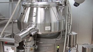 Diosna Granulator P1250 mit angeschlossenen Behältern für die Granulierflüssigkeiten sowie dem Pufferbehälter für das Feuchtgranulat: links, der Übergang von der Bedienebene des Granulators zu der Arbeitsplattform der Pelletherstellung (Bild: Losan)