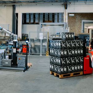 Mehr Effizienz beim Handling von Kartons! Denn während ein Raumland-Mitarbeiter eine vollgestapelte Palette holt, palettiert der UR20-Cobot munter weiter.(Bild:  Universal Robots)