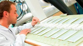 Ein Forscher der Oxis Labs in Oxfordshire, England, platziert Akkuzellen auf einer Testplattform (Bild: Oxis)