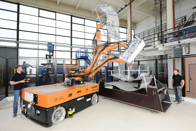 Für die Erforschung mobiler und automatisierter Herstellung großer Bauteile aus faserverstärkten Kunststoffen stehen der TU Braunschweig zwei mobile, batteriebetriebene Industrieroboter zur Verfügung, die eigenständig große Leichtbaustrukturen produzieren können. Die mobilen Produktionsroboter „KMR Quantec-TUBS“ wurden im Rahmen der Kooperation „DLR@UNI“ vom Institut für Adaptronik und Funktionsintegration der Technischen Universität Braunschweig und vom Institut für Faserverbundleichtbau und Adaptronik des Deutschen Zentrums für Luft- und Raumfahrt in Braunschweig konzipiert. (Bild: DLR)