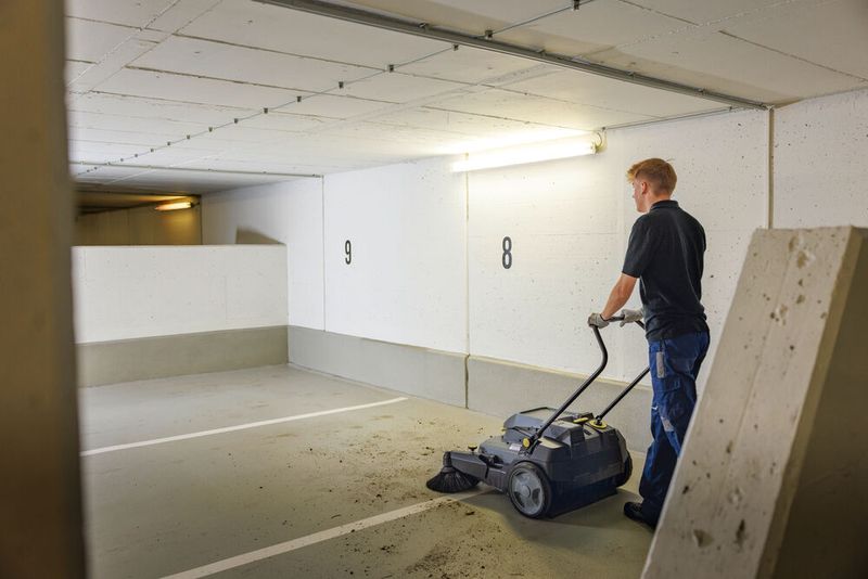 Die regelmäßige Reinigung von angrenzenden Außenflächen, etwa mit der akkubetriebenen Kehrmaschine KM 70/30 C Bp von Kärcher, vermindert den Schmutzeintrag ins Gebäude. (Bild: Kärcher)