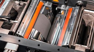 Umweltfreundlich! Blick in den Kalanderspalt der sogenannten Drytraec-Anlage am Fraunhofer-IWS in Dresden, mit der man nach Zugabe von trockenem Ausgansmaterial Batterieelektroden ohne schädliche Lösungsmittel herstellen kann. (Fraunhofer-IWS)