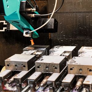 Wenn die Bearbeitungsmaschine das Signal «fertig» an den Roboter sendet, betätigt der Roboter über ein Pneumatikventil einen Zylinder und öffnet die Maschinentür, fährt in die Maschine ein und reinigt zunächst mit einer Luftblasvorrichtung das Werkstück von Kühlemulsion.