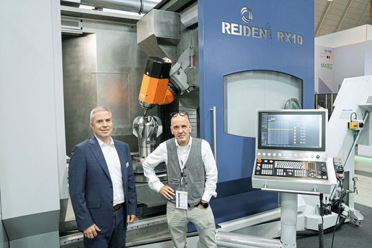Daniel Lustenberger (li.), Co-Geschäftsführer der Reiden Technik AG, und Matthias Böhm (re.), SMM-Chefredaktor, vor der «RX10 Generation 3» auf der AMB 2026.(Bild:  Nastassja Neumaier)