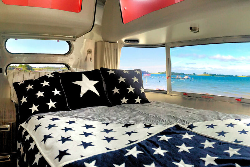 Zur enthaltenen Sonderausstattung gehören Bettwäsche, Plaids und Dekokissen im Sternenlook. (Foto: Airstream)