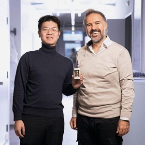Jinsong Zhang und Mario El Kazzi (von links nach rechts) mit einer Testzelle der am Paul Scherrer Institut PSI entwickelten Festkörperbatterie. Die beiden Forscher haben ein Verfahren entwickelt, das mildes Sintern mit einer ultradünnen Lithiumfluorid-Beschichtung kombiniert und so besonders stabile Festkörperelektrolyte ermöglicht. (Bild:  PSI/Mahir Dzambegovic)