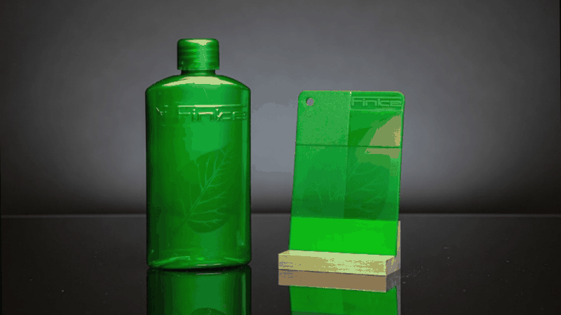 Gelaserte Flasche und Kunststoffplättchen mit hologrammähnlicher Markierung – erzeugt mit dem neuen Laseradditiv von Finke Colors in transparentem Polymer, ohne Veränderung der Oberfläche.(Bild:  Finke Colors)