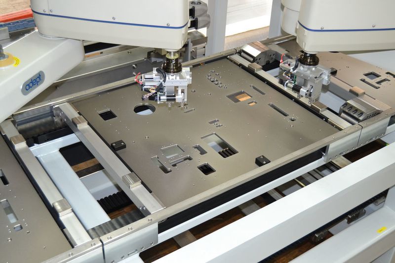 Roboterstation: Der Warenträger liegt nicht auf dem Zahnriemen, sondern auf L-förmigen Edelstahlwinkeln auf, die an Riemennocken und Aluminium-Querträger befestigt sind. (Bild: Mulco)