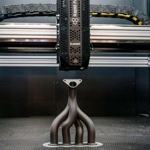 Ein 3D-Drucker bei der Arbeit an einer Art Abgaskrümmer respektive Medienverteilersystem. Das ist wieder so ein komplexes Teil, das in der Rüstung seinen Einsatz findet, weshalb die Mesago Messe Frankfurt der Formnext erstmals einen Defence-Bereich gibt.(Bild:  Mesago)