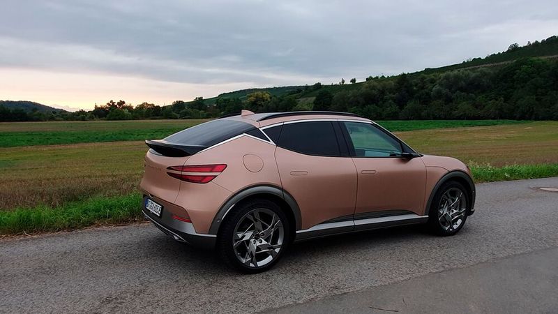 1. Das Design: Es verwundert nicht, dass der GV60 bereits begehrte Designpreise eingeheimst hat: Im Vergleich zu den oftmals recht wuchtig anmutenden Wettbewerbern, wirkt die Linienführung des GV60 auch dank der versenkten Türgriffe von allen Seiten elegant und sportlich zugleich. Erstaunlich ist, dass dem GV60 eigentlich alle Farben gut stehen – ob ein ästhetisches weiß, ein knalliges Limettengelb oder der matte, leicht rosa wirkende Kupferton des  Testwagens in der Topversion Sport Plus. (Bild: Mauritz – VCG)