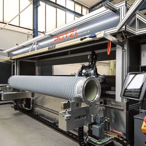 Ein Isolator liegt in der Aufnahme. Gut zu erkennen sind die vorderen Laufrollen sowie die beiden Antriebe.(Bild:  SEW-Eurodrive)