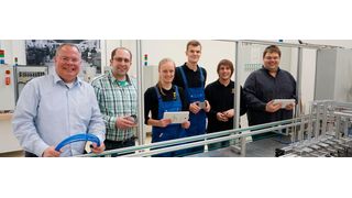 Nico Gottlieb (Ausbildungsleiter), Artur Maurer (Ausbilder), Adina Brandt (duale Studentin Maschinenbau), Rino Richter (Auszubildender zum Mechatroniker), Pascal Haßebrock (dualer Student Mechatronik) und Jacob Knierim (Ausbilder; von links nach rechts) an der „Ausbildungseinheit Industrie 4.0“: Blechdosen können per Smartphone individuell mit Schokoladentäfelchen bestückt werden. (Bild: Harting)