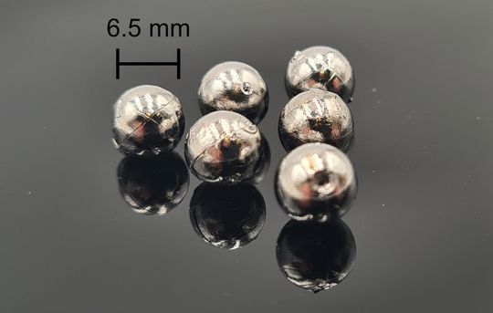 Solche Kügelchen aus metallischem Glas – hier Nickel-Niob-Schwefel – warten bereits auf der ISS. Sie werden ohne Schmelztiegel verflüssigt und als bis zu 1700 Grad heiße, schwebende Tropfen untersucht.(Bild:  Lucas Ruschel)