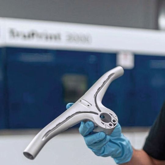 Dank generativer Fertigung lassen sich Kanäle für Kabel und Bremszüge so in den Fahrradlenker aus Aluminium integrieren, dass man sie einfach ein-, ausbauen und warten kann. (Bild:  Trumpf)