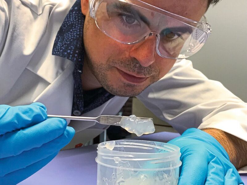 Empa-Forscher Gilberto Siqueira mit einem Glas der Nanocellulose (Empa)